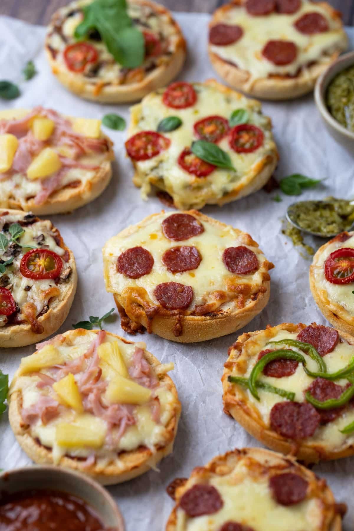 pizza muffins on a table with pizza sauce.