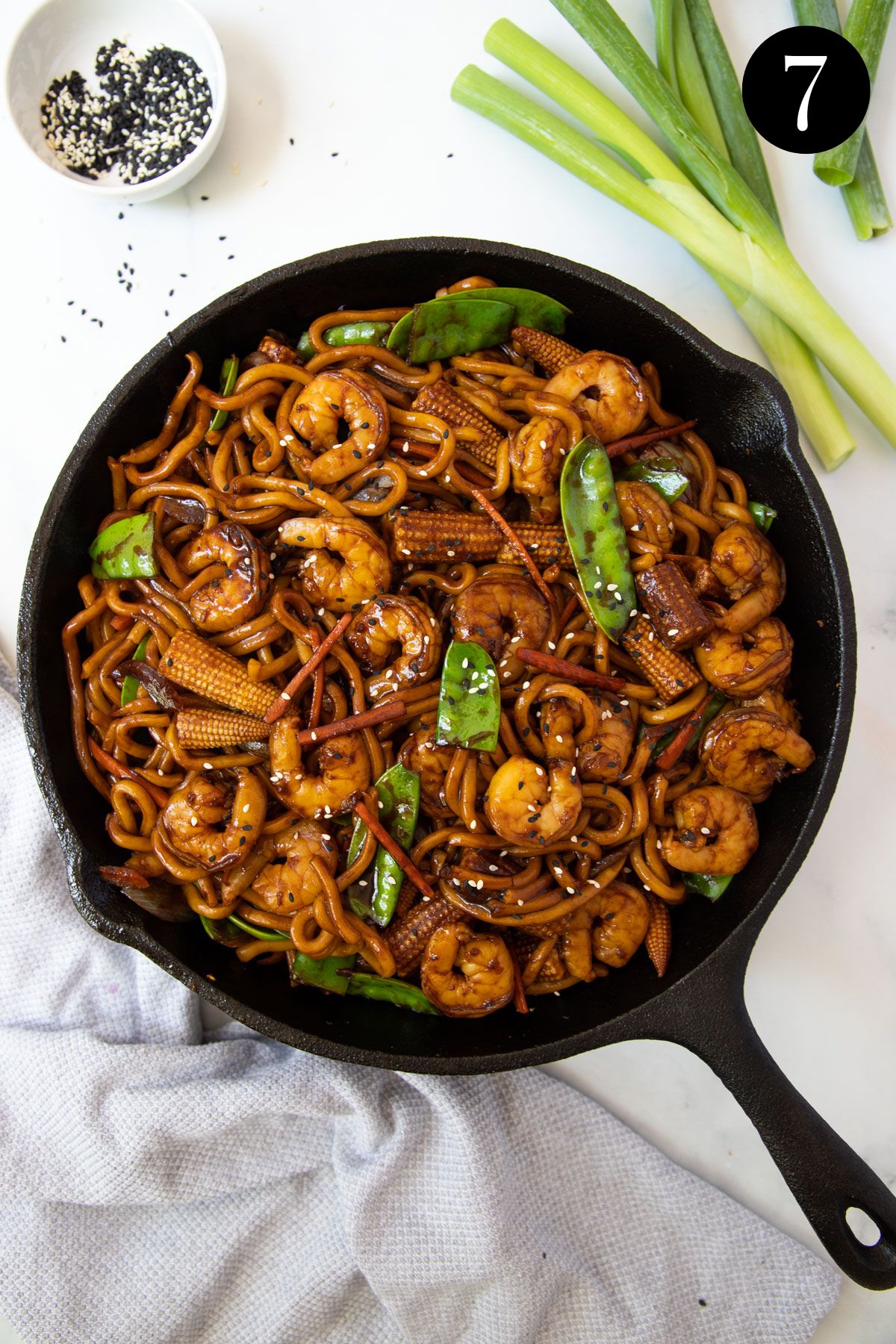 stir fry in a pan with noodles, prawns and vegetables.