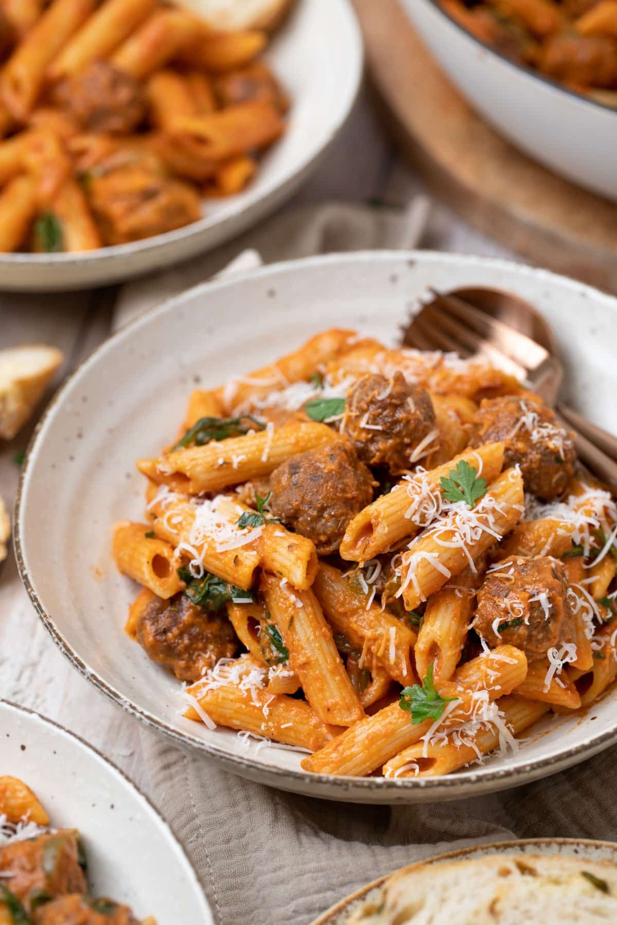 a bowl of sausage pasta topped with cheese.