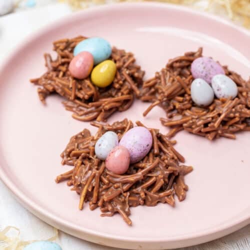 chocolate nests on a plate, topped with Easter eggs.