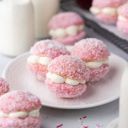 pink jelly cakes filled with cream on a white plate.