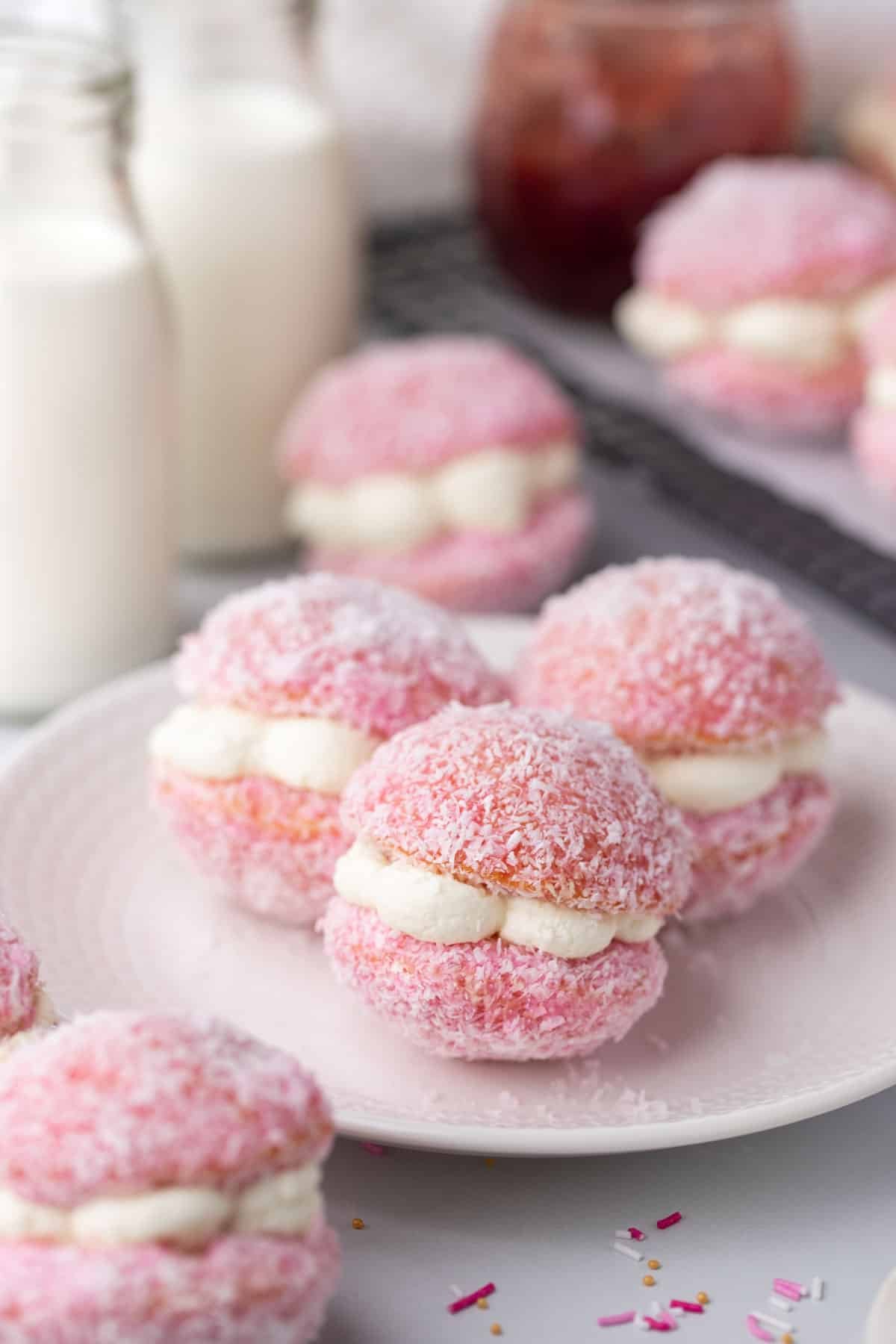 a plate with pink jelly cakes, filled with cream.