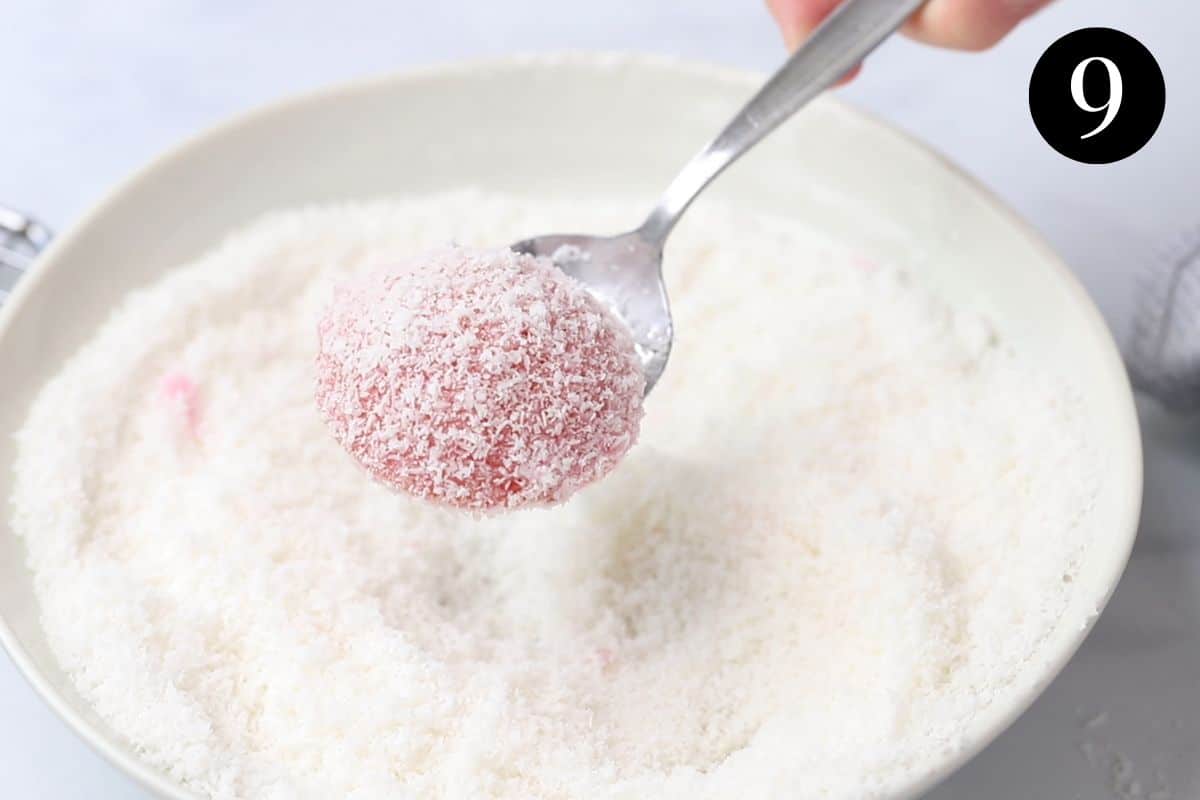a spoon holding a pink cake, coated in coconut.