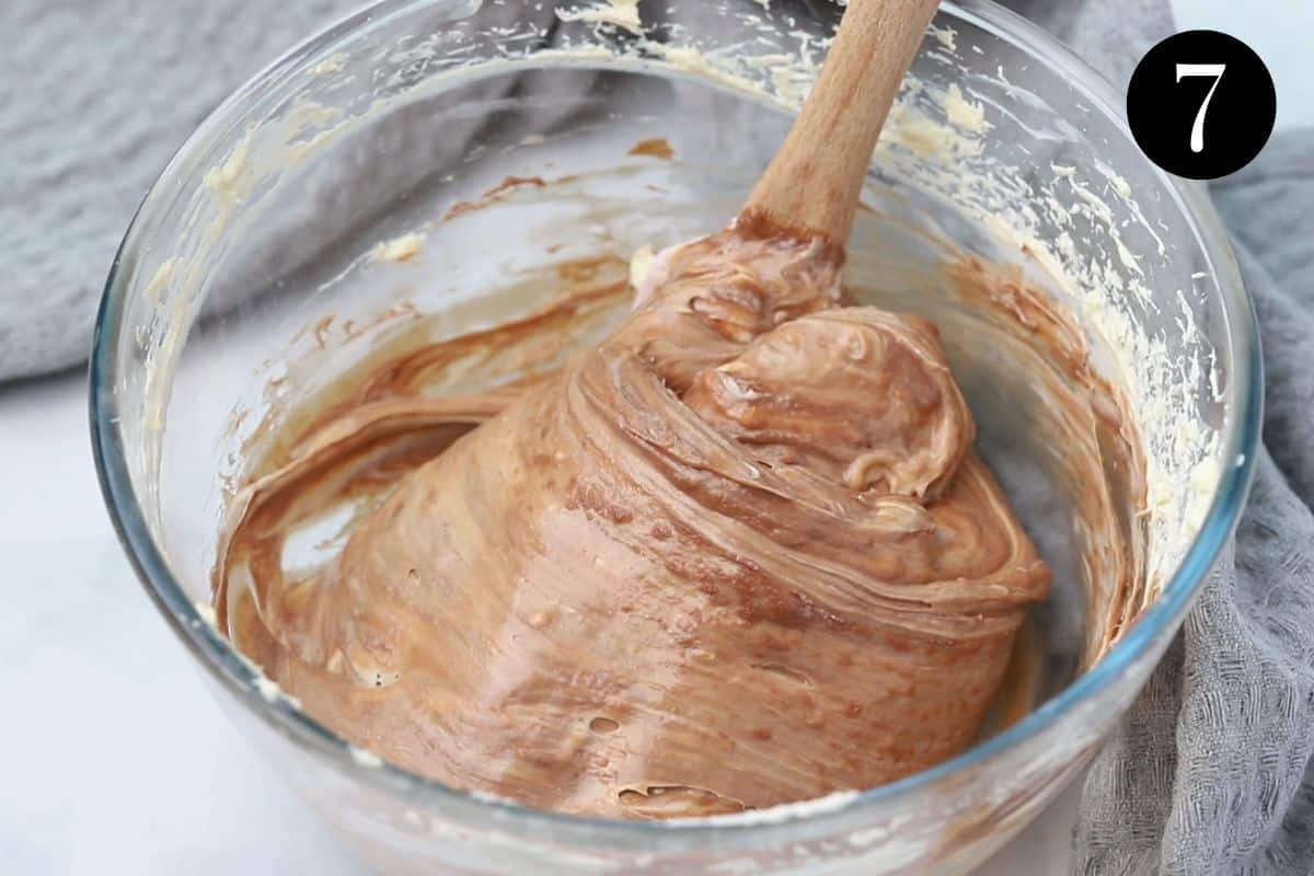 a spatula folding chocolate into cream cheese filling.