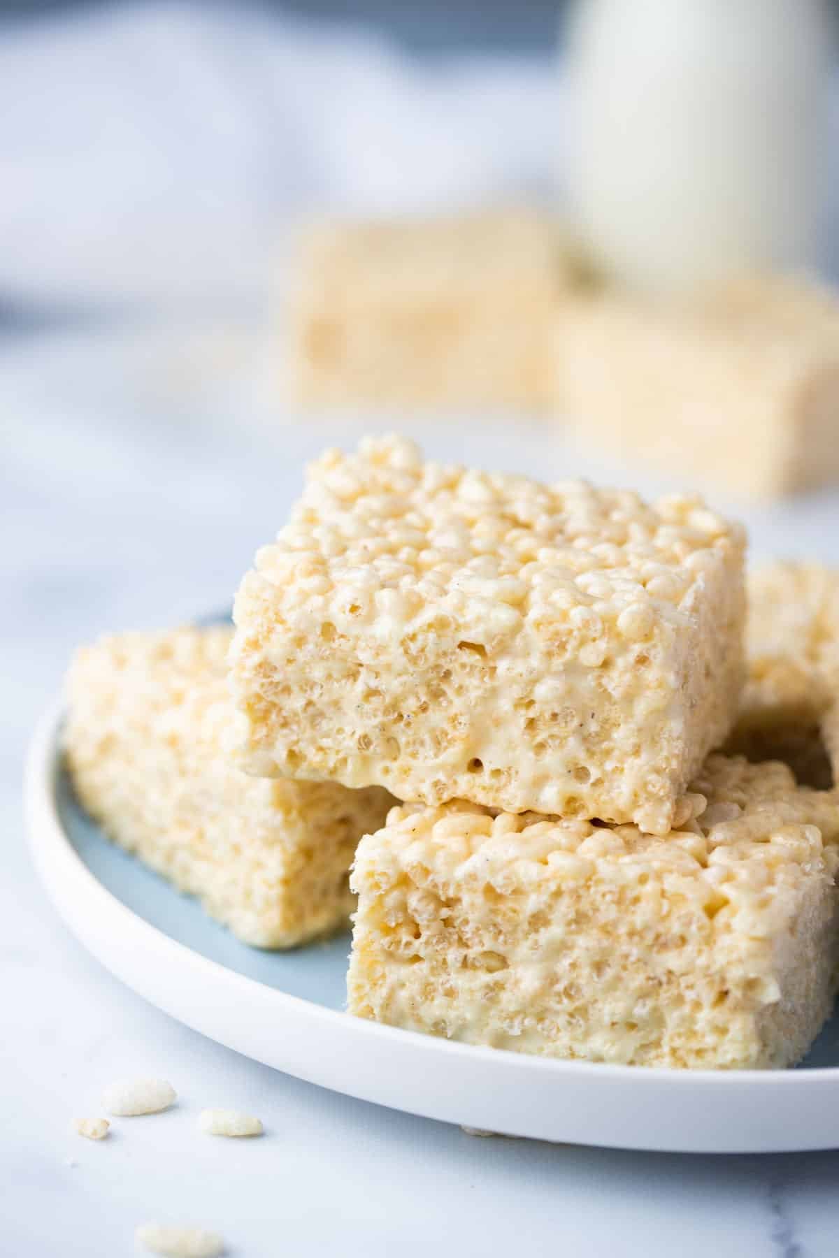 square pieces of Rice Bubble slice, stacked on a blue plate.