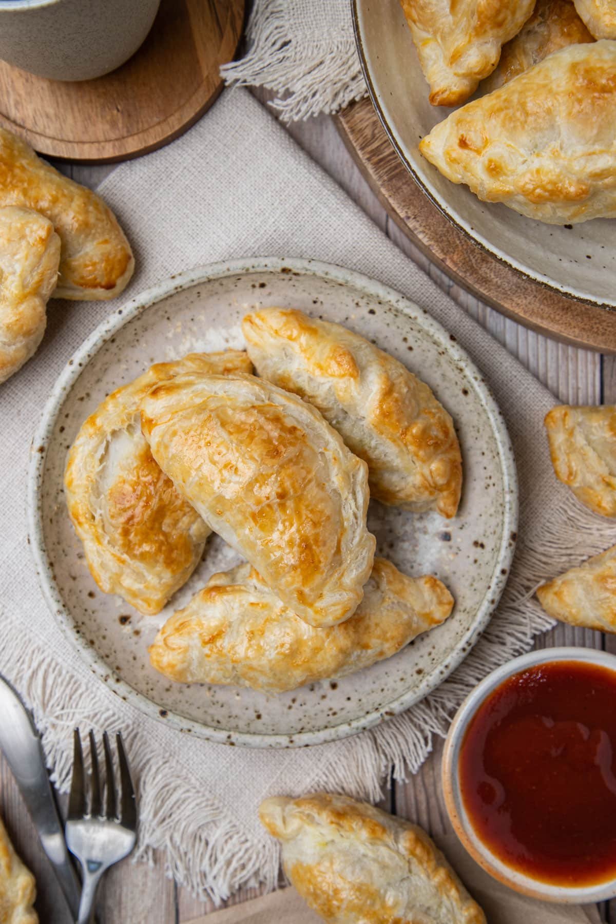 pasties arranged on a plate, with tomato sauce.