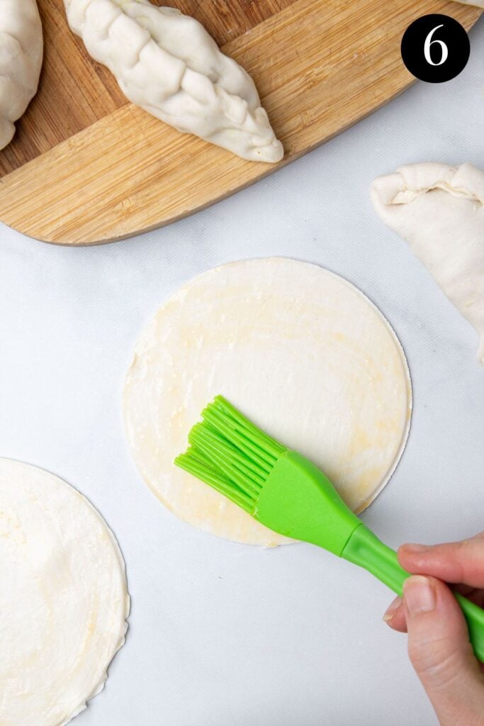 egg being brushed over a pastry circle.