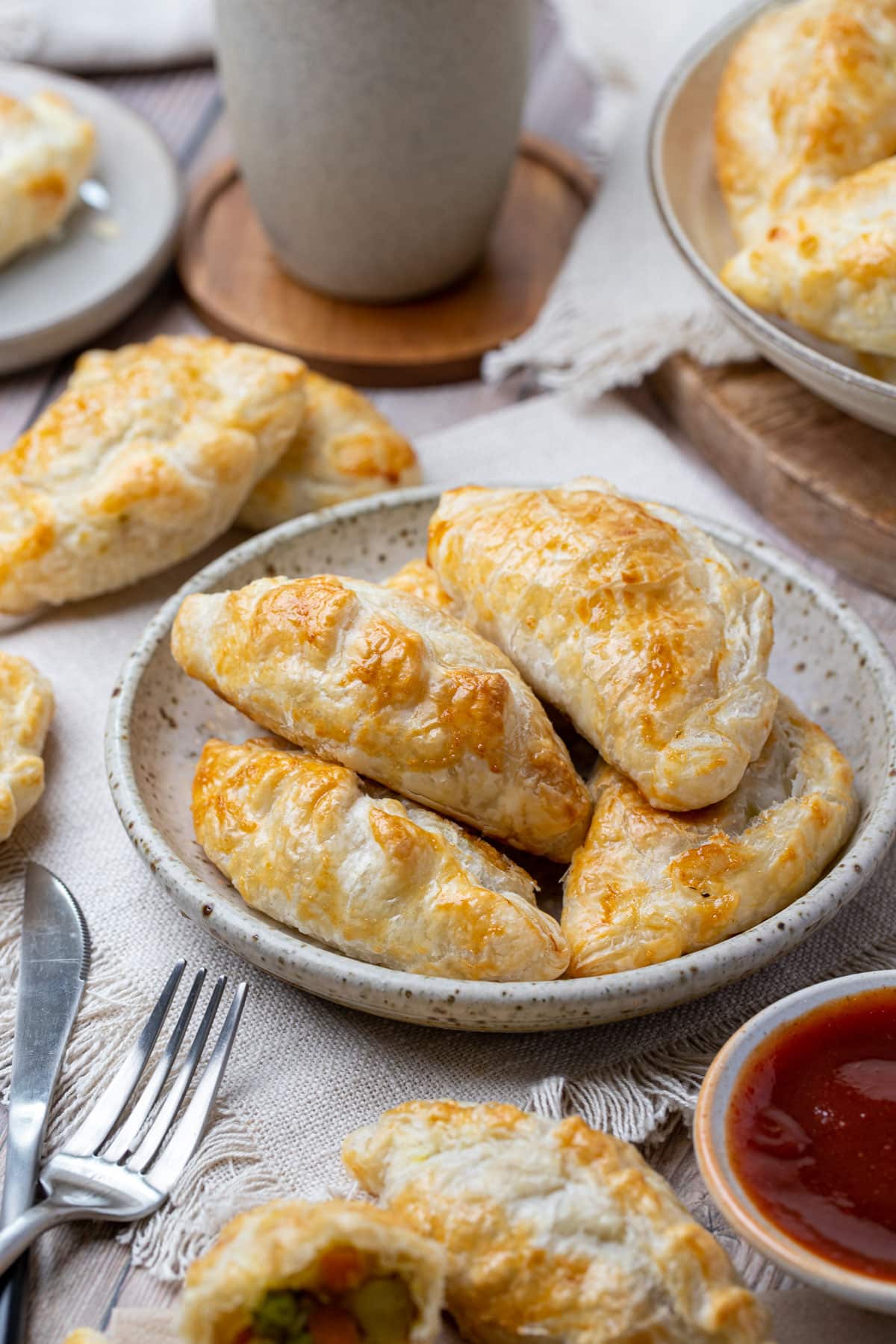 pasties on a plate with tomato sauce and cutlery.