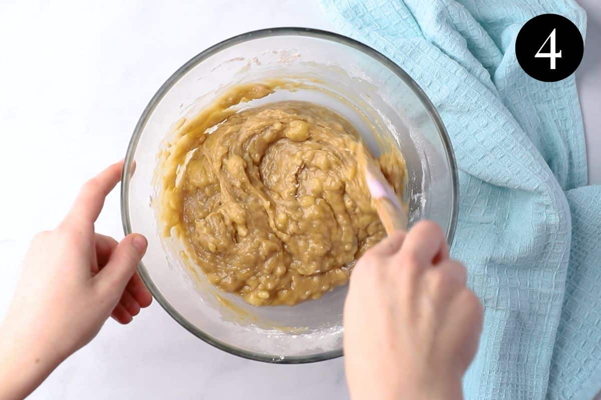 hands mixing batter in a bowl.