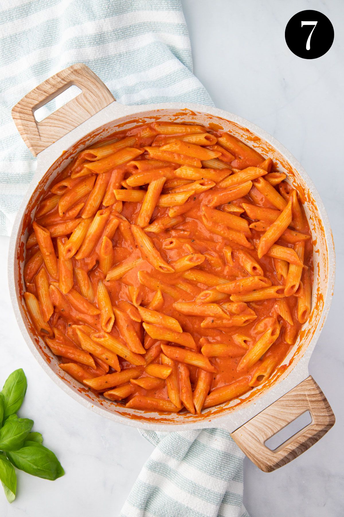 creamy tomato pasta in a white pan.