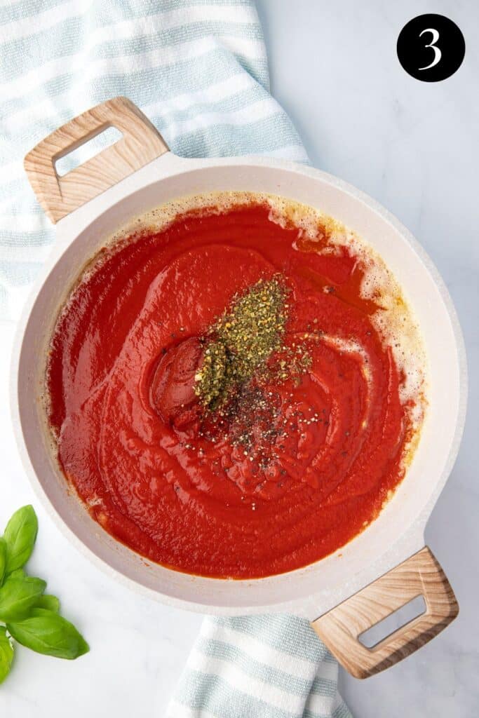 passata and herbs in a pan.