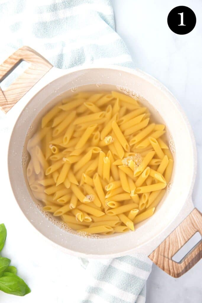 a pot of penne pasta in water.