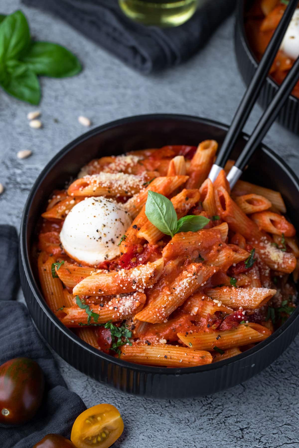 a bowl of penne pasta topped with creamy sauce and cheese.