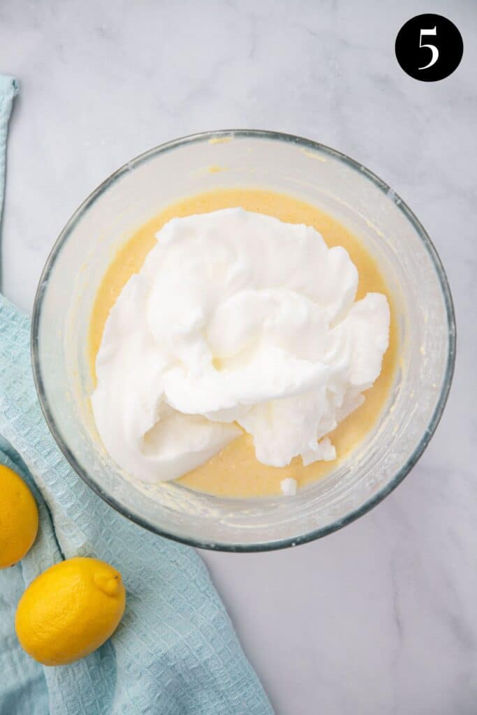 beaten egg whites added to cake batter in a mixing bowl.