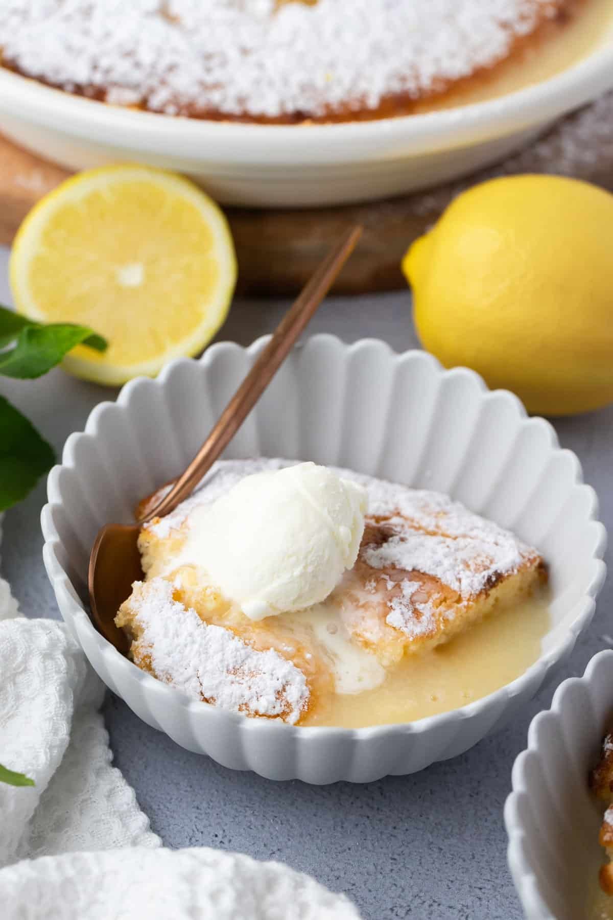 a bowl of lemon sponge pudding topped with ice cream.