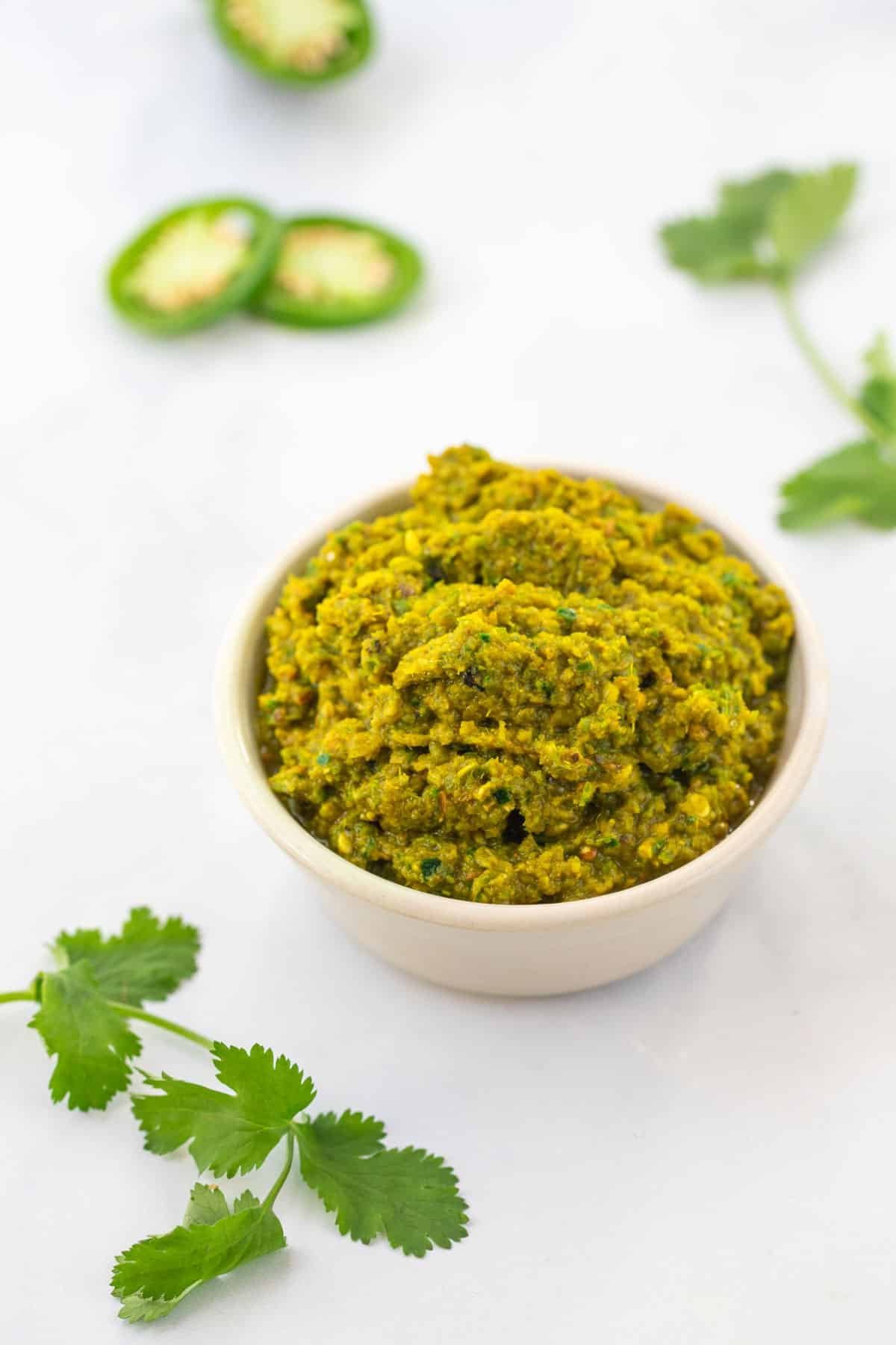 a bowl of green curry paste on a table.