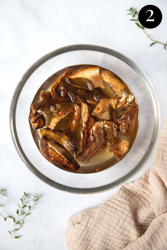 a bowl of porcini mushrooms soaking in water.