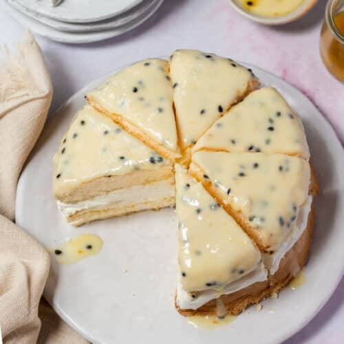 sponge cake on a plate topped with passion fruit icing.