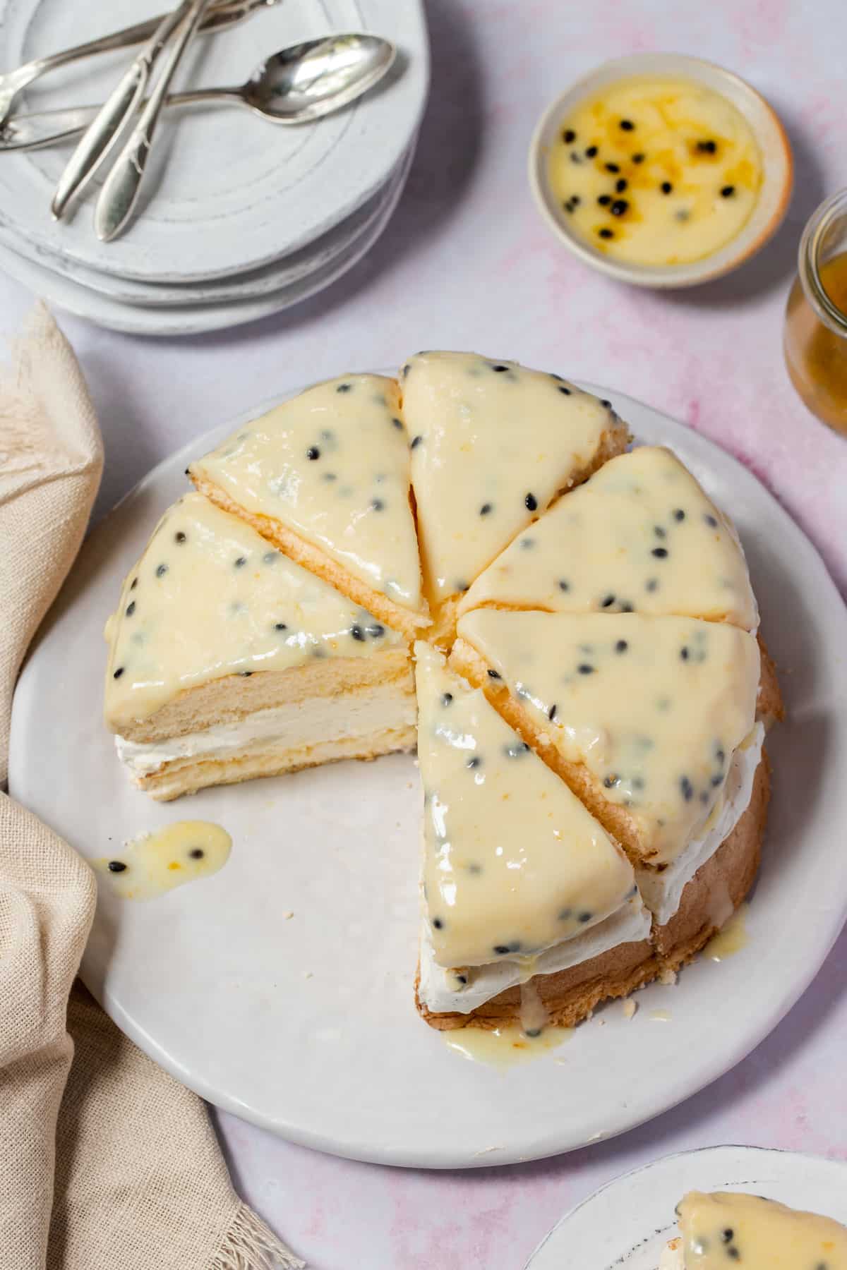 sponge cake cut into slices on a plate, topped with passionfruit icing.