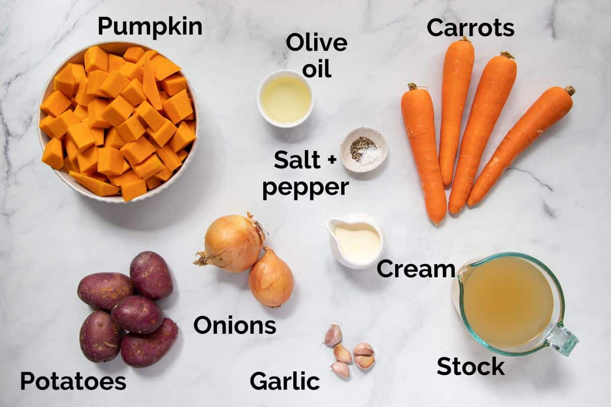 all ingredients for pumpkin and carrot soup, laid out on a table.