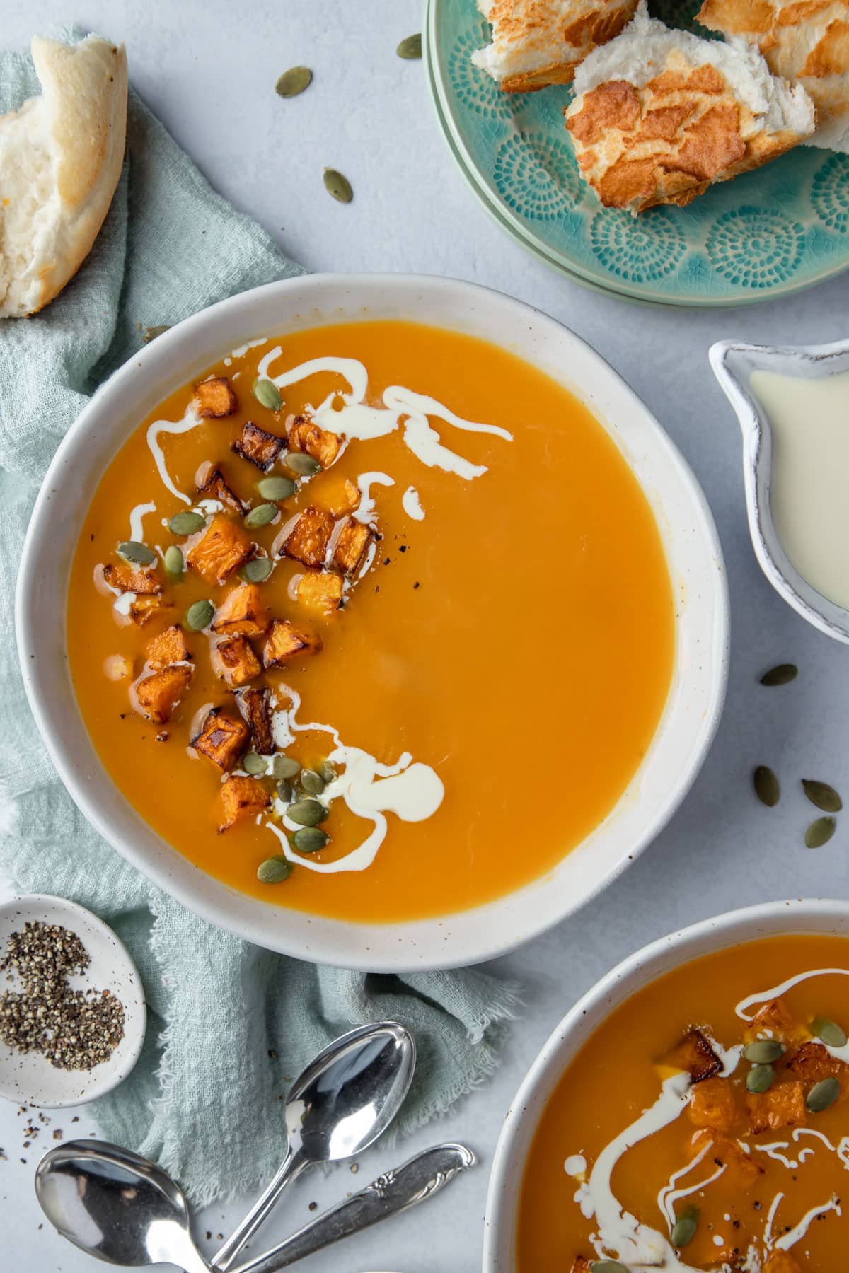 a bowl of soup topped with cubes of pumpkin and cream.