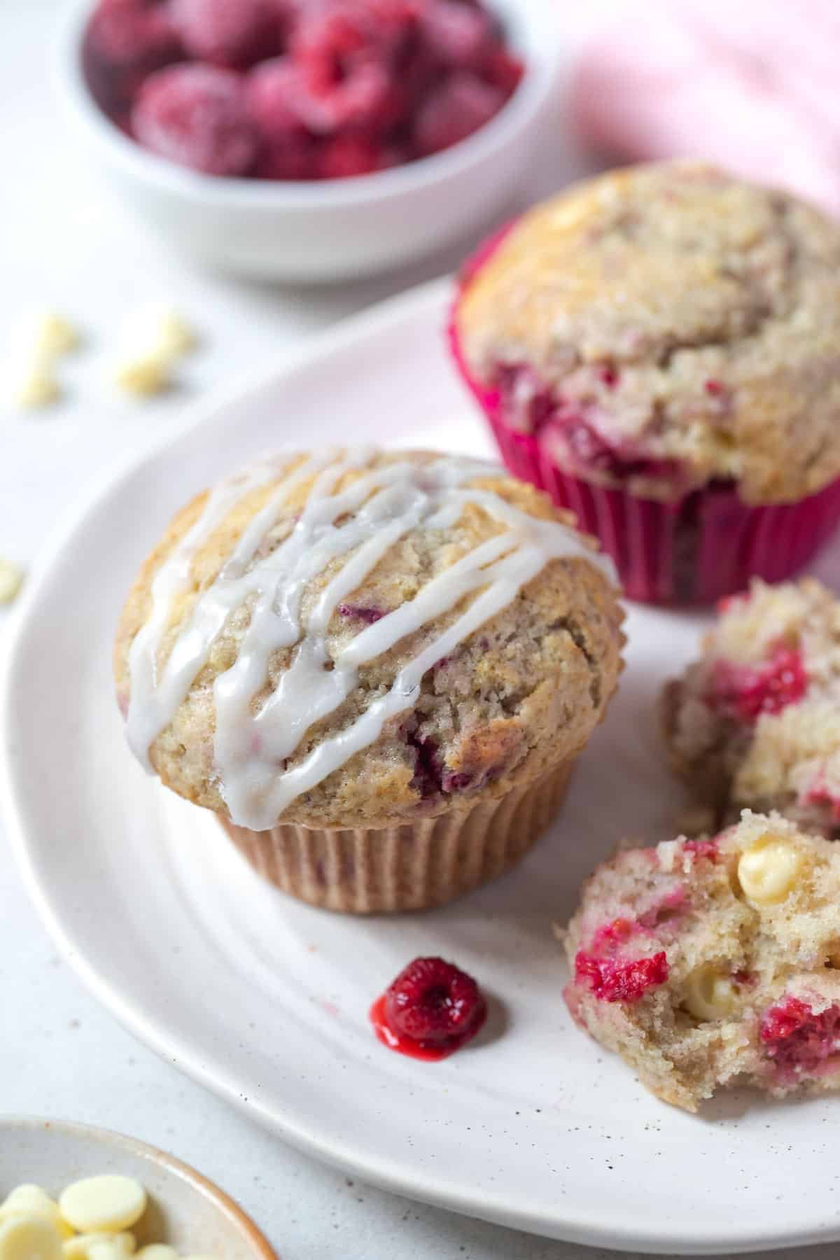 a plate with muffins and raspberries.