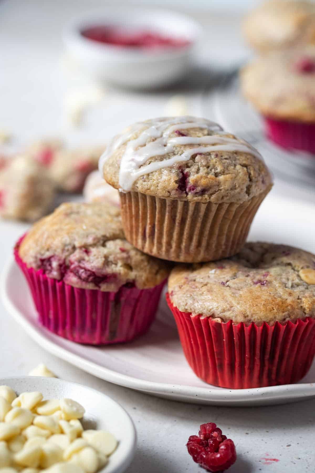 a plate of raspberry and white chocolate muffins on a table.