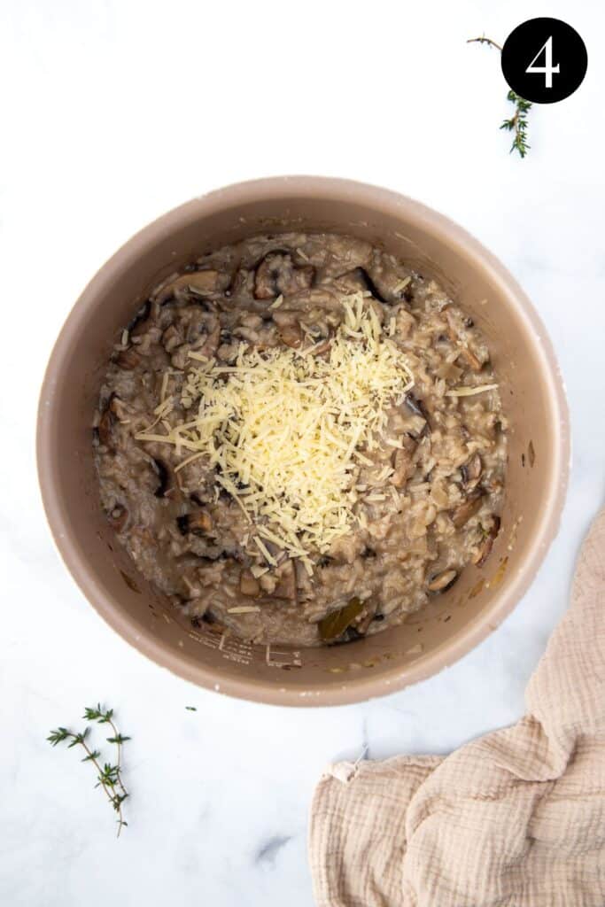 finished risotto in a slow cooker pot, with grated parmesan cheese.