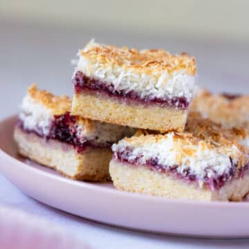pieces of raspberry coconut slice, arranged on a plate.