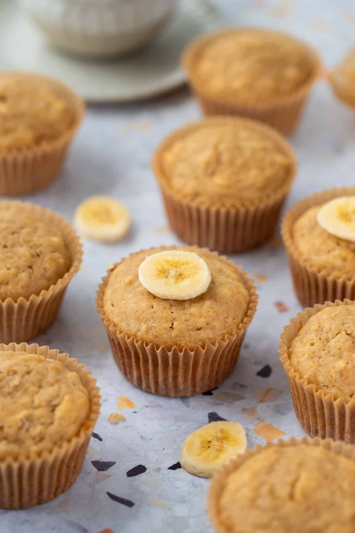 muffins in paper cases arranged on a table.