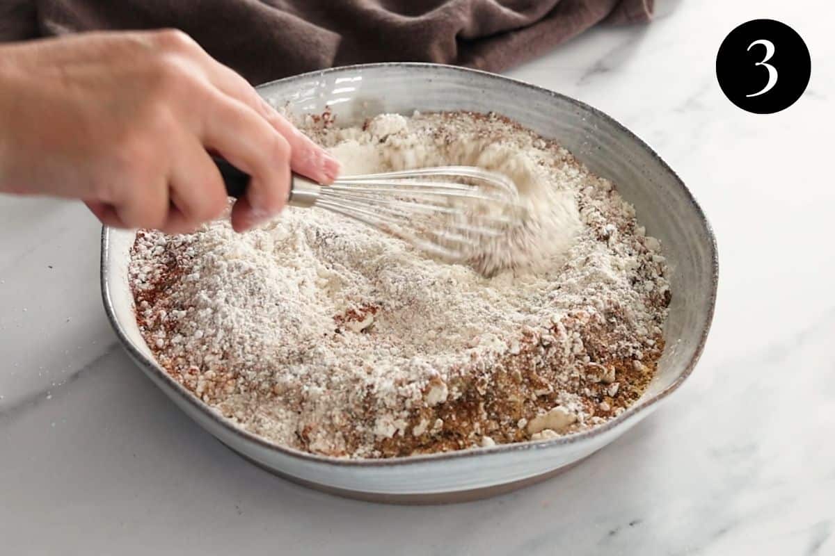 flour and spices being whisked in a bowl.