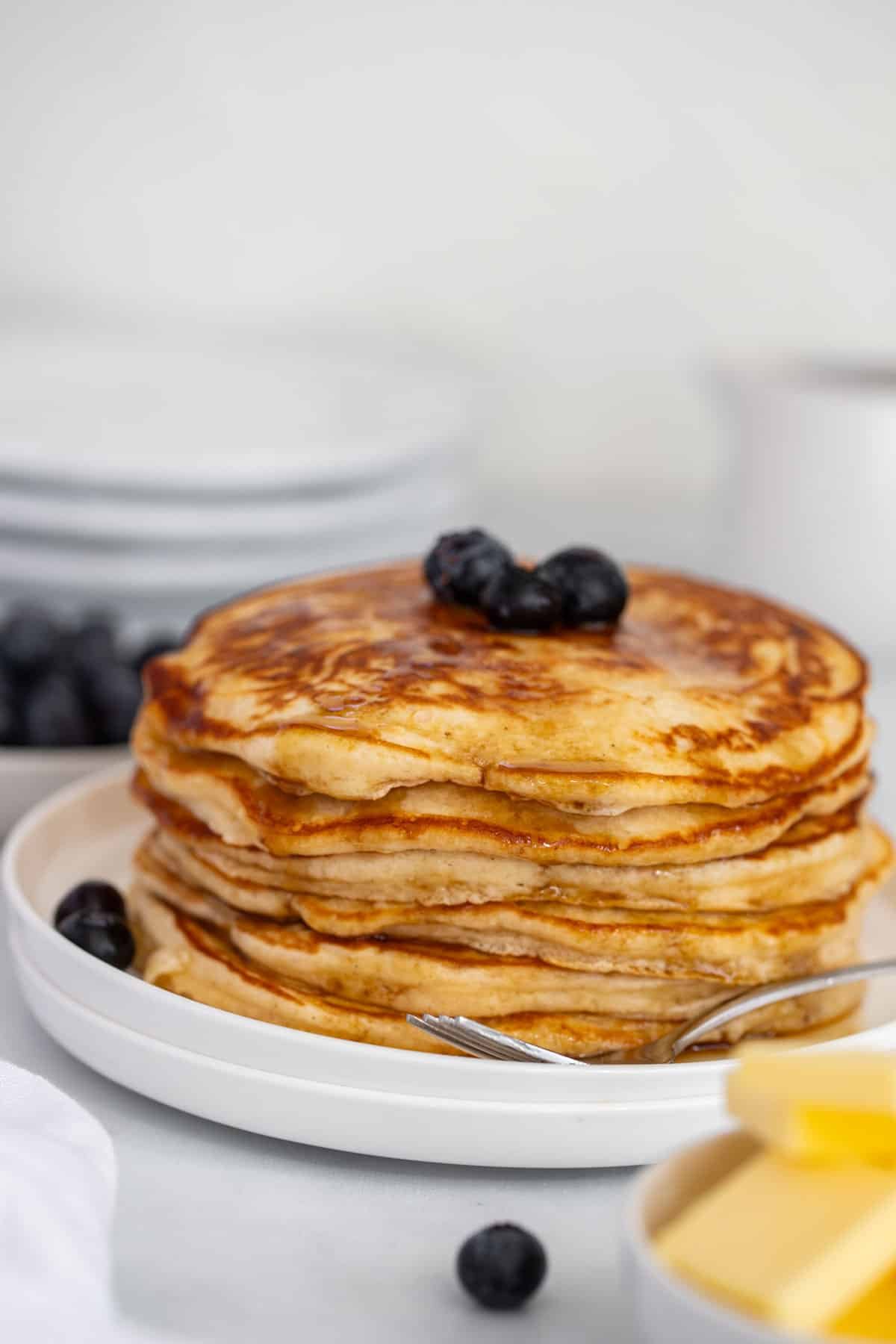 a plate of pancakes with blueberries and butter.