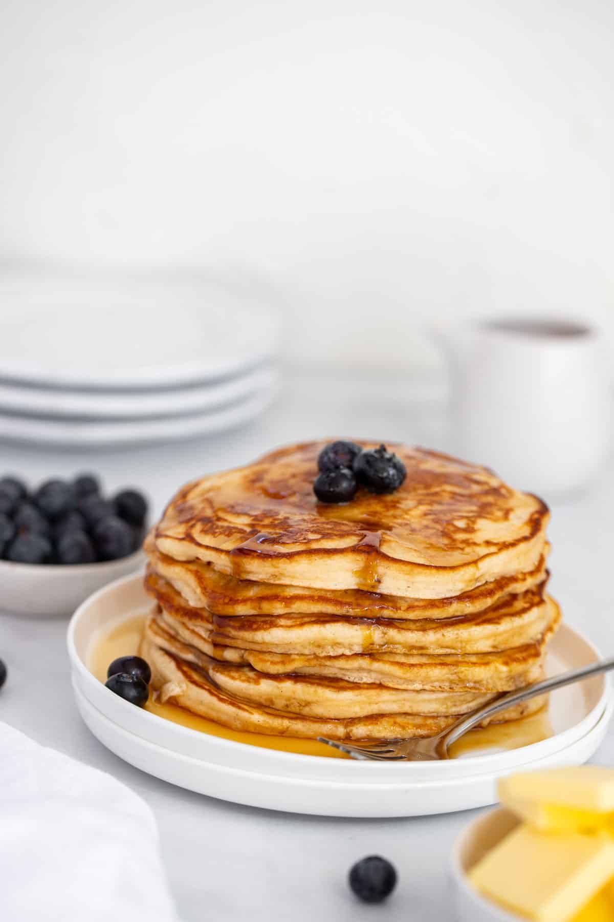 a plate of pancakes topped with blueberries.