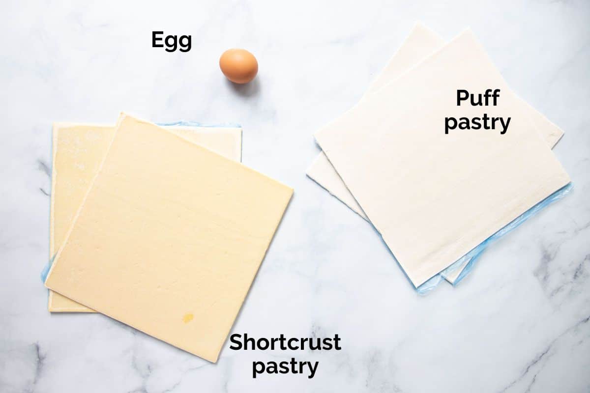 puff pastry sheets and an egg, laid out on a table.
