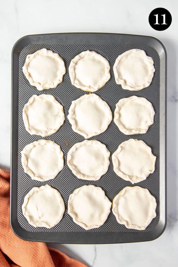 pies in a muffin tin, topped with puff pastry lids.