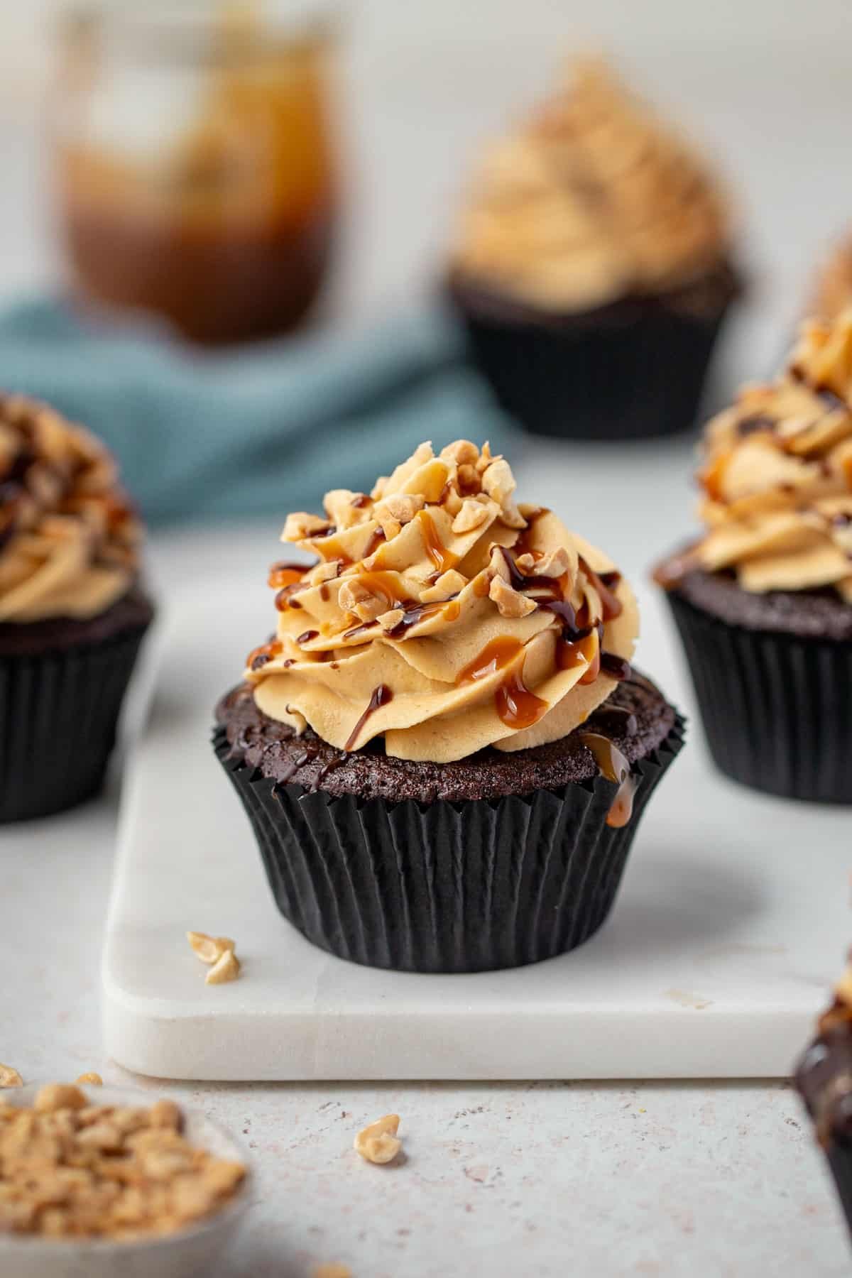 a cupcake on a marble board, with peanuts.