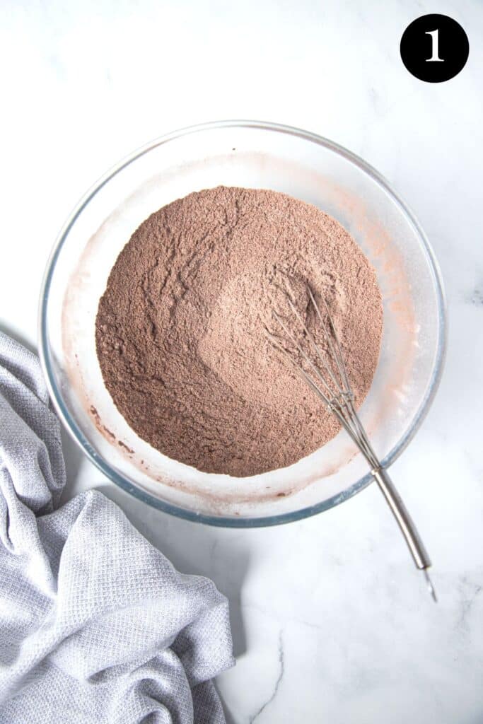 dry cupcake ingredients in a bowl with a whisk.