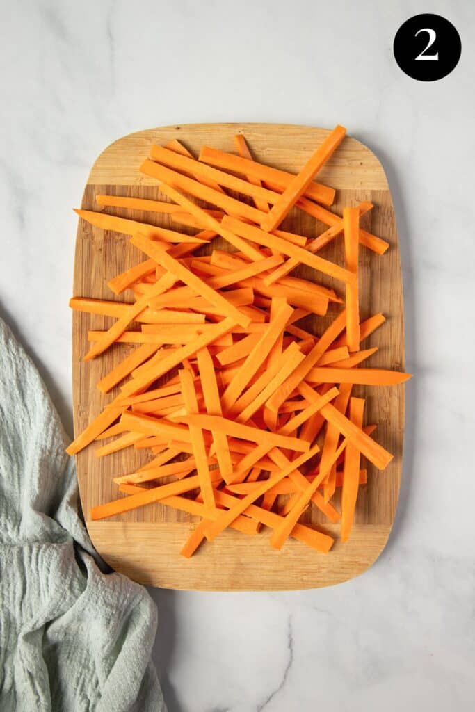 sliced sweet potato fries on a wooden board.