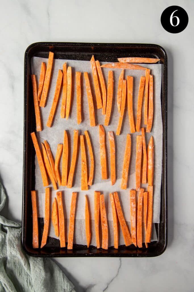 sweet potato fries arranged on a baking tray.