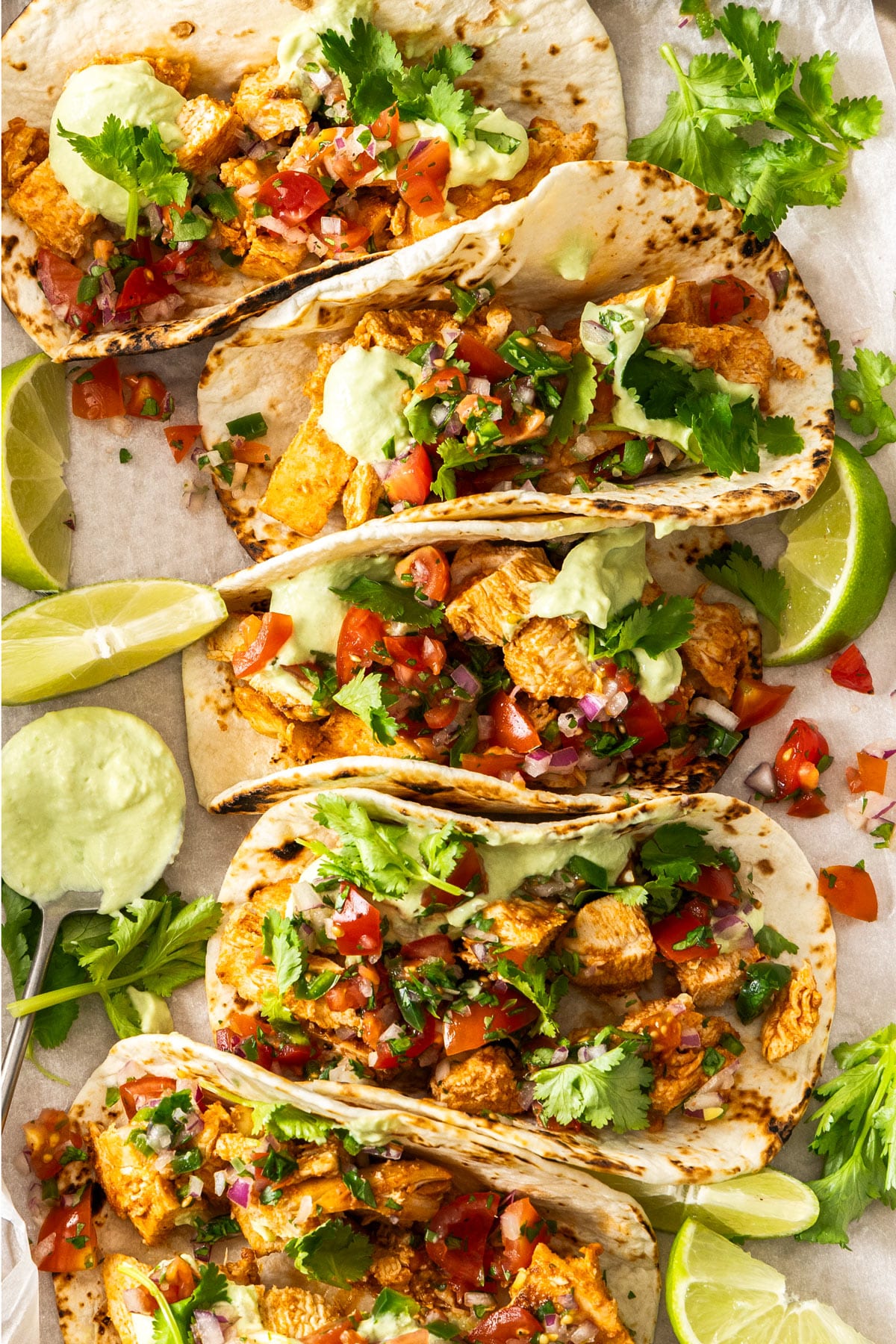 chicken tacos topped with salsa, arranged on a tray.