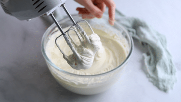 electric beaters whipping cream in a bowl.

