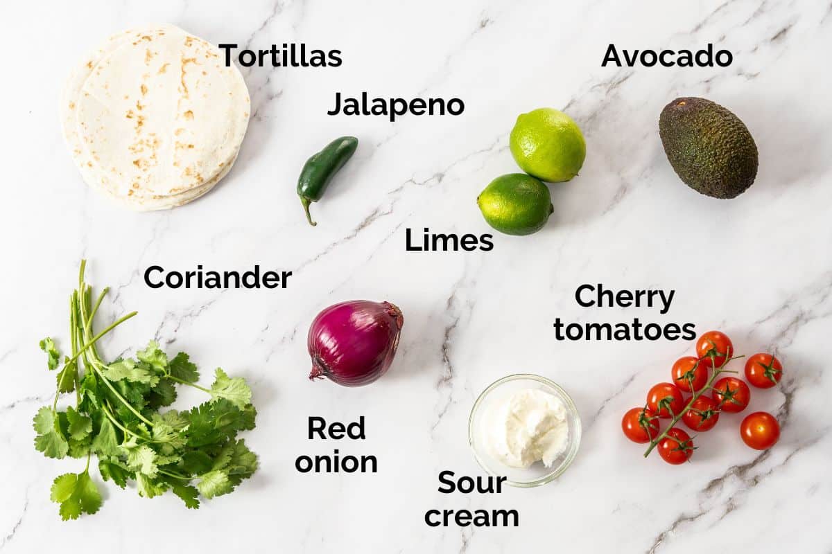 all ingredients for tomato salsa and avocado sauce, laid out on a table.