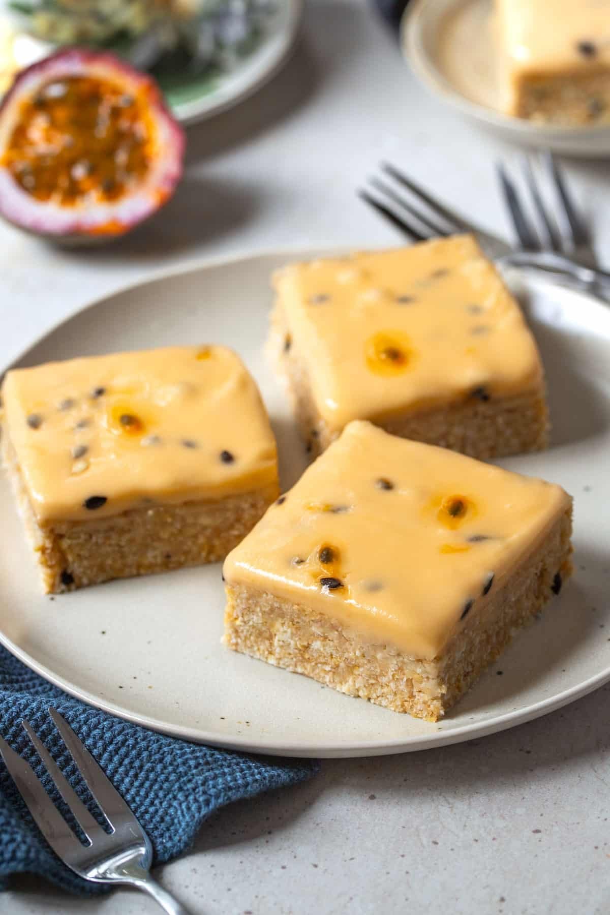 pieces of slice topped with passion fruit icing, arranged on a plate.
