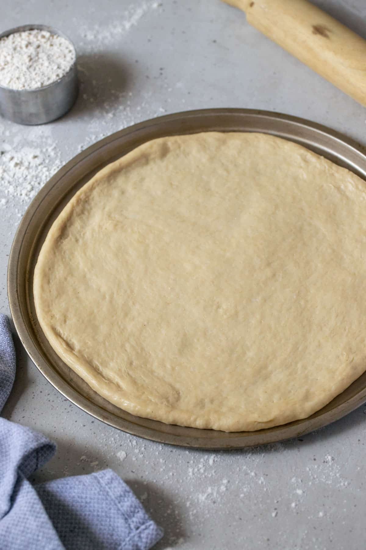 pizza dough shaped onto a tray.