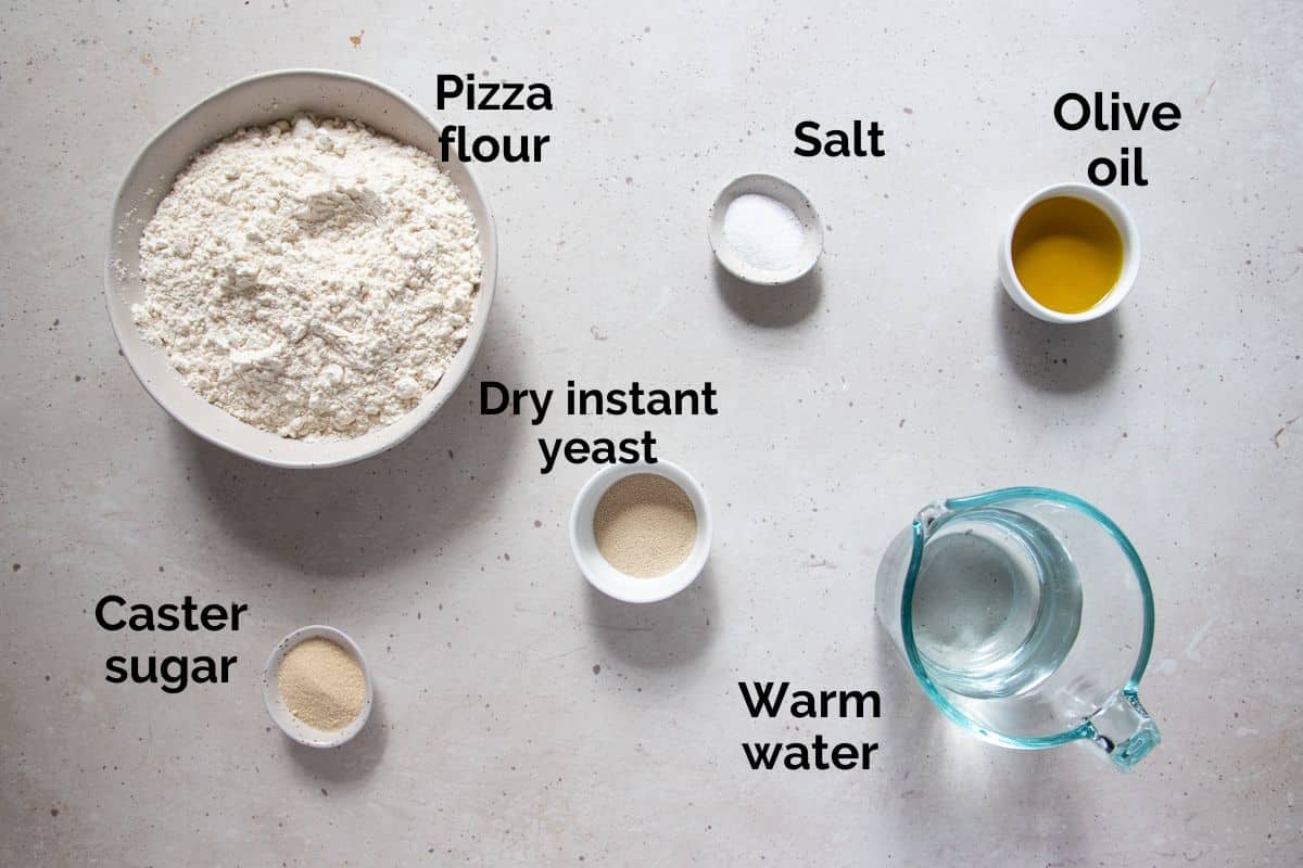 all ingredients for pizza dough laid out on a table.