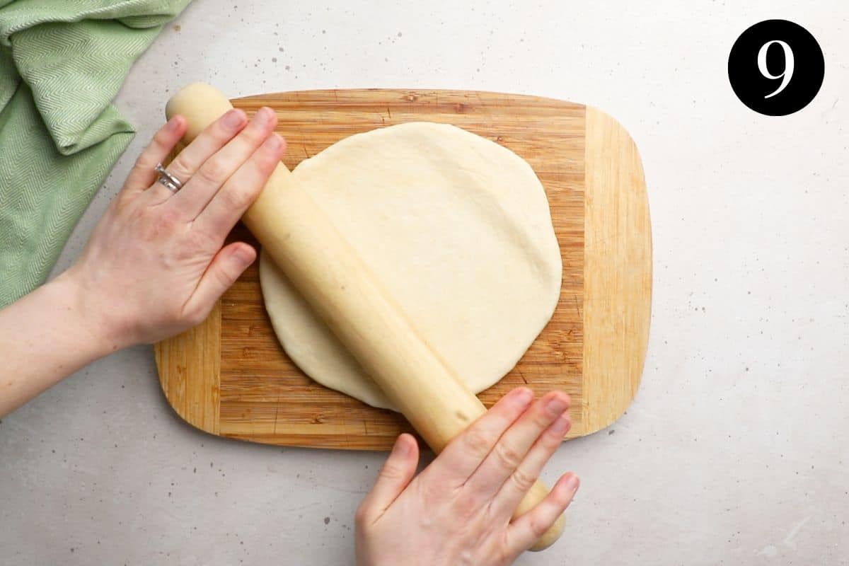 dough being rolled into a disc shape with a rolling pin.