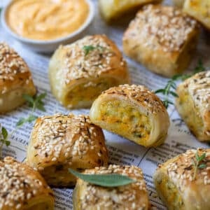 chicken sausage rolls on a table with sage leaves.