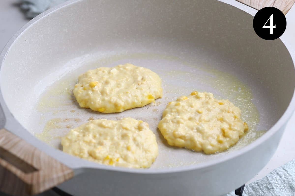 corn fritters frying in a pan.