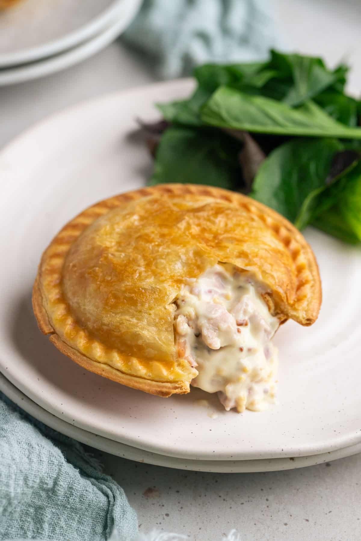 a chicken pie on a plate, with salad.