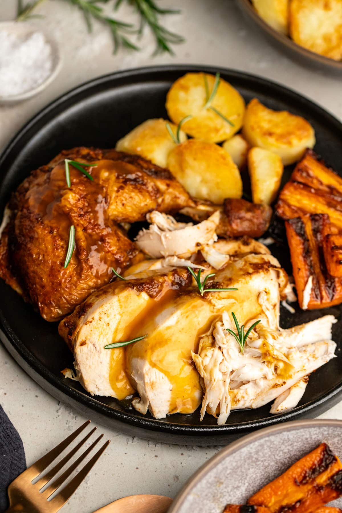 a plate with roasted vegetables and chicken, topped with gravy.